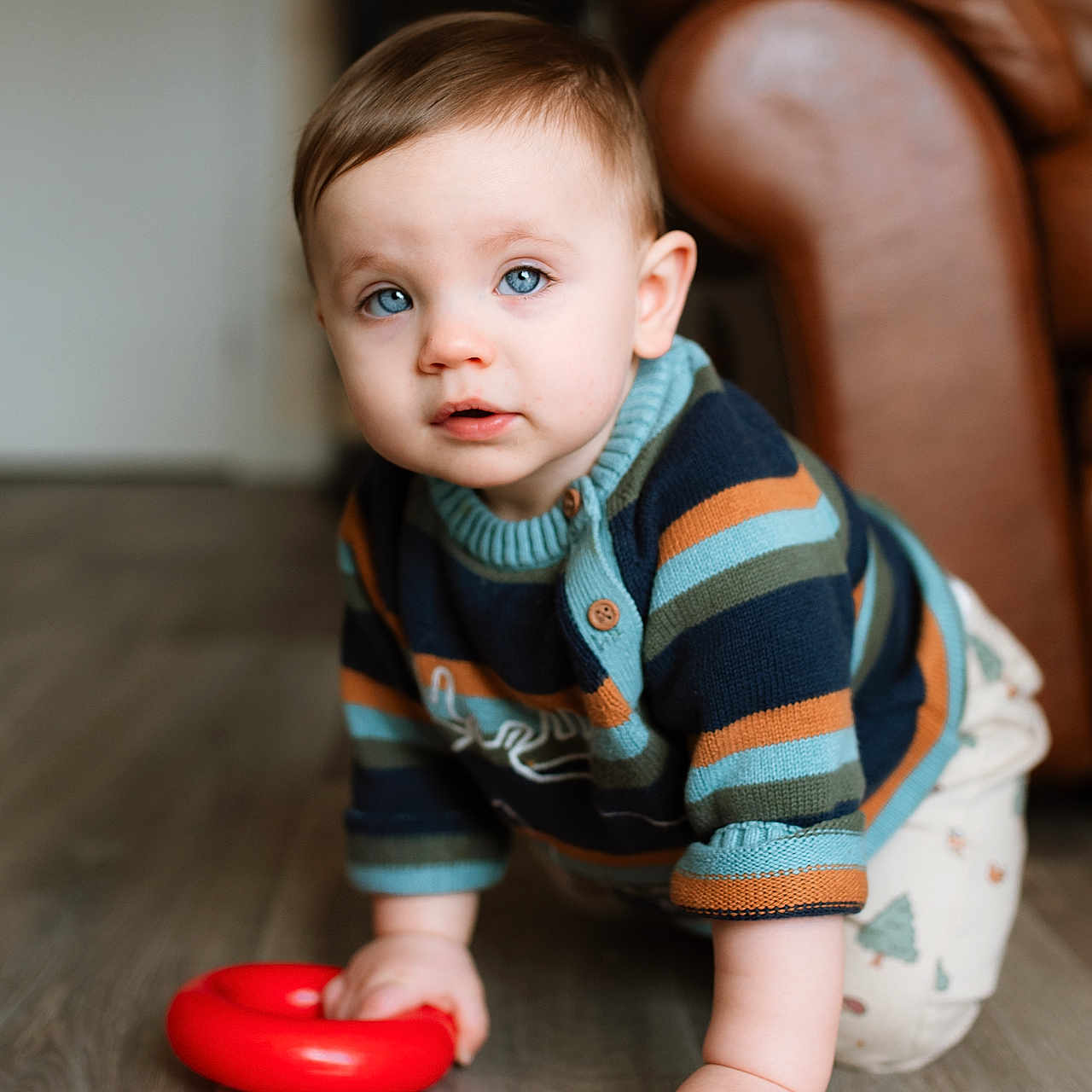 Vincent is registered to the contest to win money with this photo: baby, babycrawling, bodypart, clothing, couch, crawling, face, finger, furniture, hand, hardwood, head, knitwear, pants, person, photography, portrait, sitting, sweater, wood