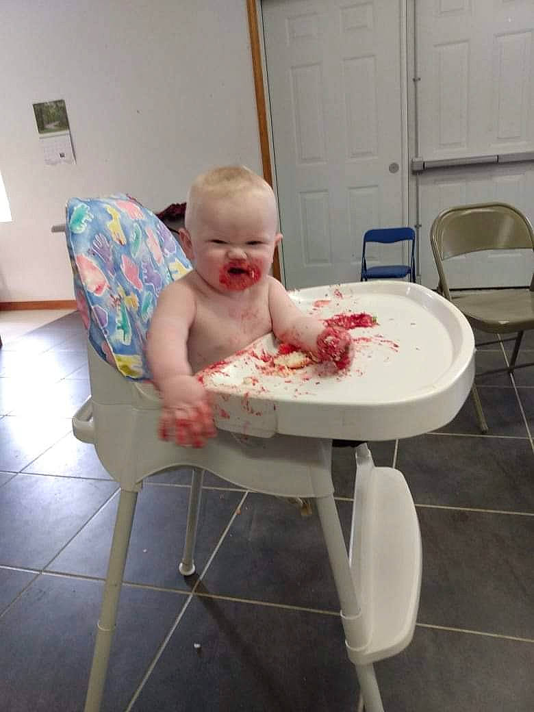 Colton is registered to the contest to win money with this photo: baby, baby_products, baby_toddler_clothing, bathing, chair, child, comfort, cooking, event, floor, flooring, furniture, human_body, leisure, person, room, sitting, smile, table, tableware