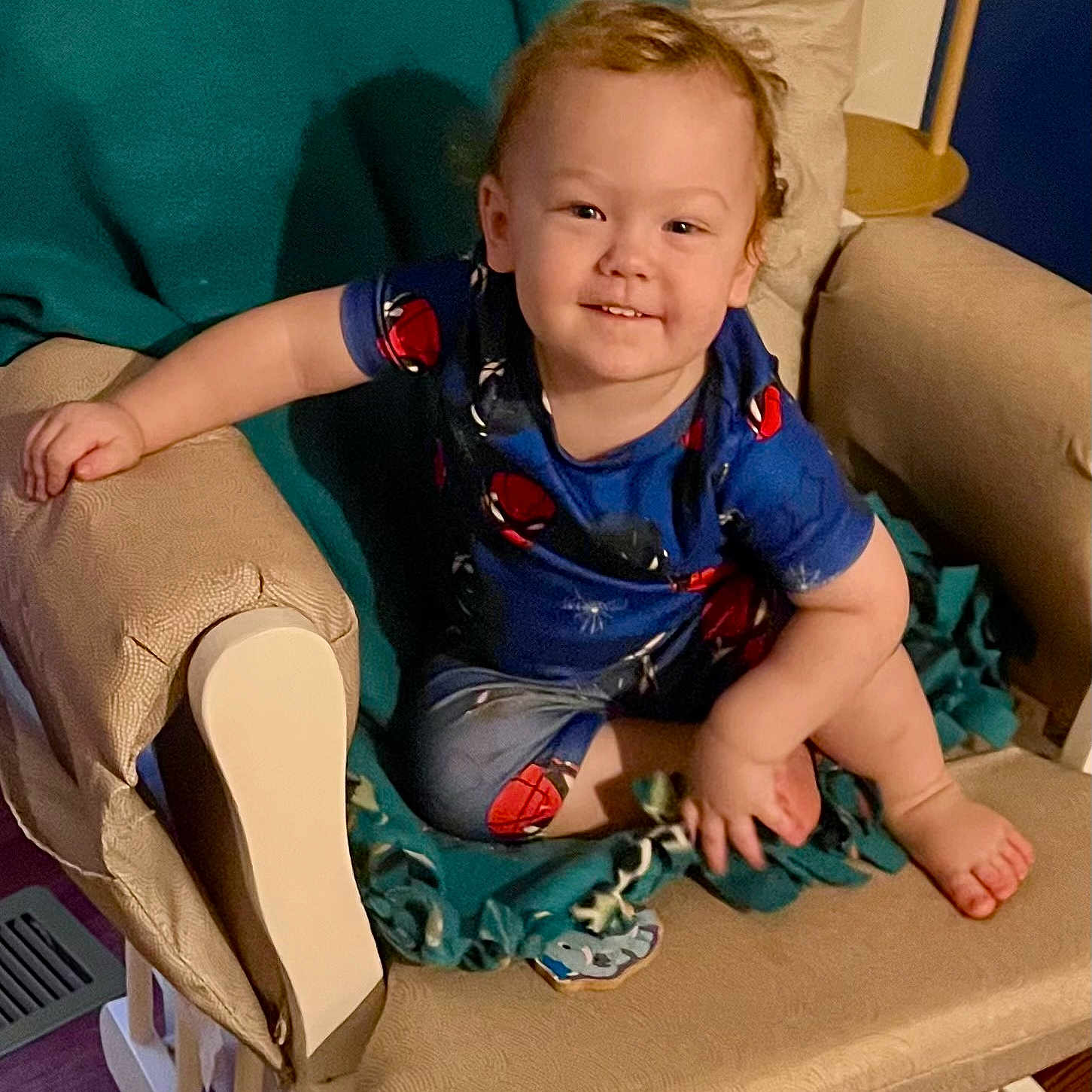 Markus joined the competition — help win amazing prizes! toddler, child, baby, sitting, smiling, portrait, face, indoor, armchair, chair, cushion, blanket, clothing, superhero_costume, blue_shirt, barefoot, living_room, furniture, happy, photography