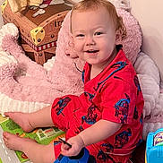 Markus joined the competition — help win amazing prizes! toddler, child, pajamas, red_clothing, spiderman, smiling, sitting, toy, shoe, play_mat, plush_toy, indoor, floor, happy, person, cute, baby, footwear, colorful, home