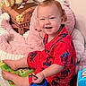 toddler, child, pajamas, red_clothing, spiderman, smiling, sitting, toy, shoe, play_mat, plush_toy, indoor, floor, happy, person, cute, baby, footwear, colorful, home