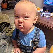 Markus joined the competition — help win amazing prizes! baby, blanket, blue_shirt, buckles, carpet, coffee_table, couch, denim_overalls, expression, funny_face, hand, indoor, infant, judgmental_look, living_room, portrait, scrunched_face, television, toddler, water_bottle