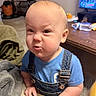 Markus joined the competition — help win amazing prizes! baby, blanket, blue_shirt, buckles, carpet, coffee_table, couch, denim_overalls, expression, funny_face, hand, indoor, infant, judgmental_look, living_room, portrait, scrunched_face, television, toddler, water_bottle