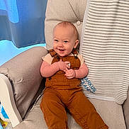 Markus is registered to the contest to win money with this photo: baby, child, smiling, overalls, armchair, blanket, curtain, indoor, happy, infant, furniture, clothing, portrait, sitting, cute, person, toddler, cozy, home, soft_lighting