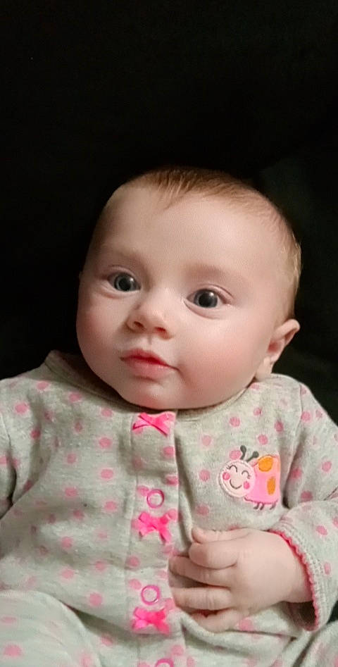 Nova is registered to the contest to win money with this photo: baby, baby_toddler_clothing, cheek, child, chin, collar, eye, eyelash, face, facial_expression, flash_photography, iris, lip, mouth, nose, outerwear, person, sitting, skin, sleeve