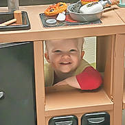 Benjamin participe au concours pour gagner de l'argent avec cette photo : child, toddler, smile, toy_kitchen, play, sink, pan, toy_food, countertop, cabinet, recycling_bin, indoor, portrait, happy, kitchen_toy, playtime, arm, face, blond_hair, cute