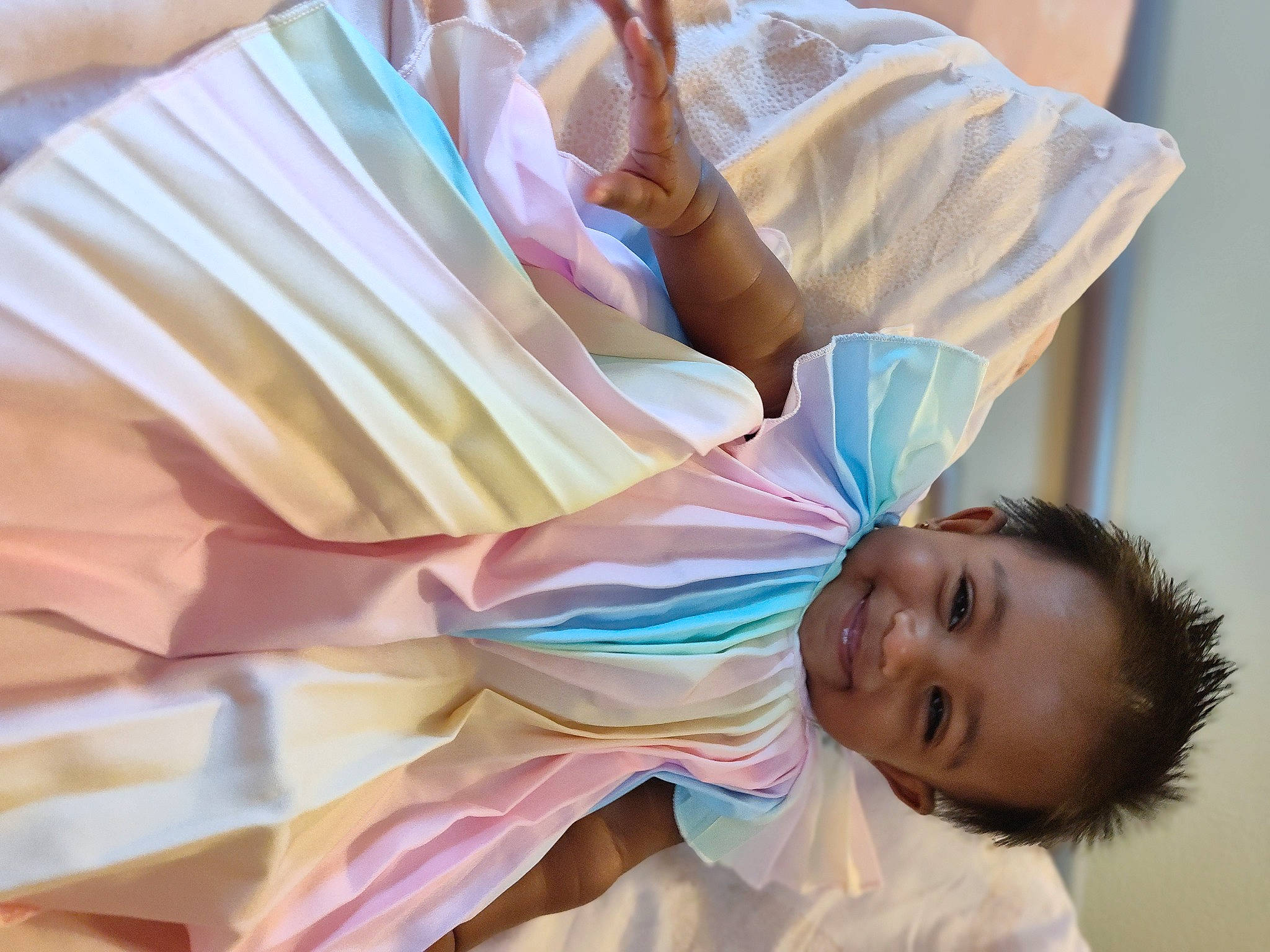 Talia is registered to the contest to win money with this photo: baby, baby_toddler_clothing, child, comfort, fun, gesture, happy, joy, linens, paper, pattern, peach, person, pink, room, sleeve, smile, t_shirt, toddler