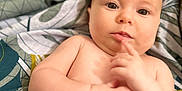 Harmony participe au concours pour gagner de l'argent avec cette photo : baby, bare_chest, blanket, child, closeup, curious, cute, expression, eyes, face, finger, hand, indoors, infant, lying_down, pattern, portrait, skin, soft, young