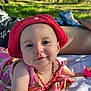 baby, blanket, child, cute, daylight, floral_dress, forest, grass, happy, infant, nature, necklace, outdoor, person, portrait, red_hat, relaxing, smiling, summer, sunlight