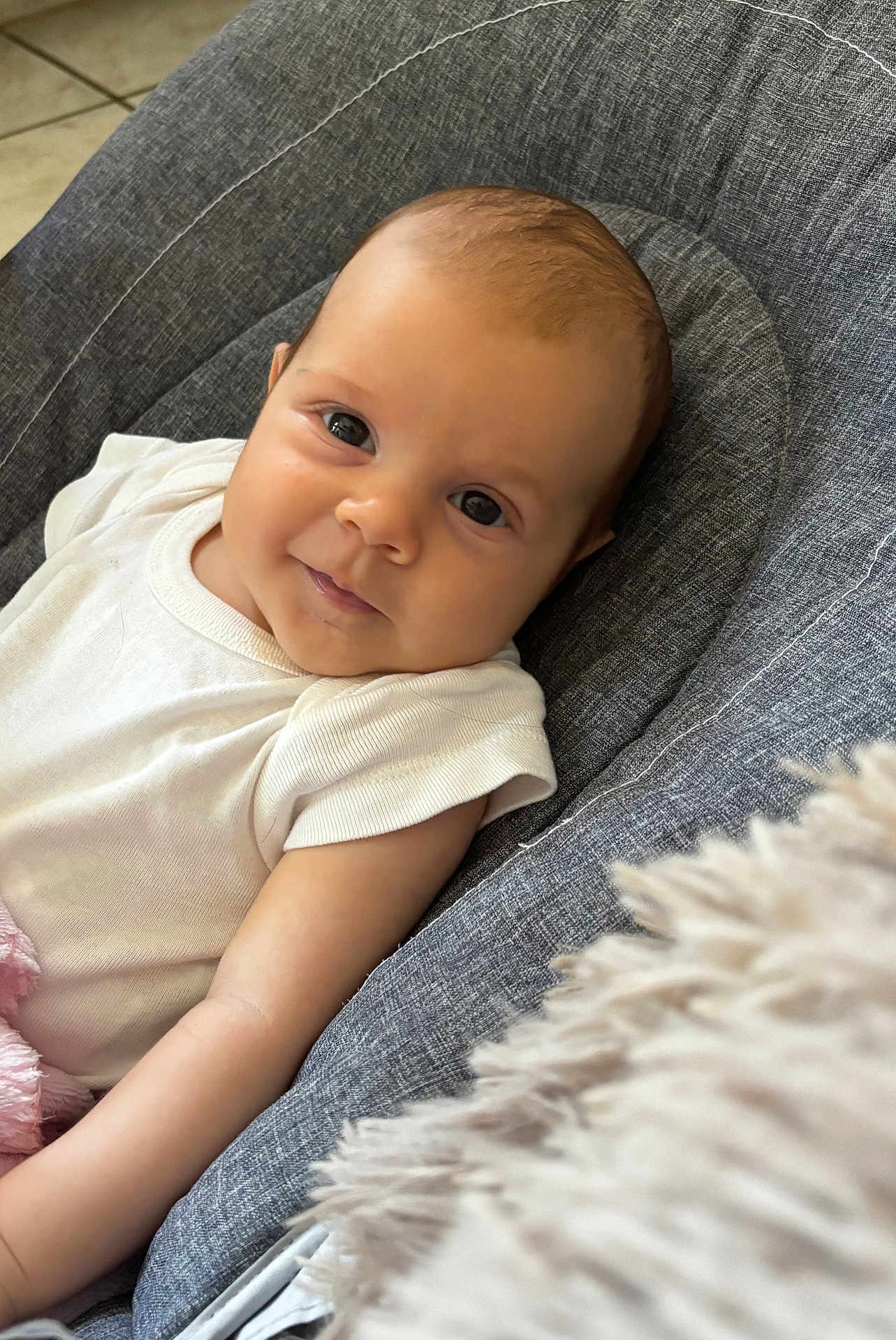 Albane a rejoint le concours — aidez-le/la à gagner de superbes lots ! baby, infant, child, smile, face, eyes, white_clothing, gray_cushion, seat, indoor, soft_texture, blanket, comfort, portrait, young_child, cute, happy, skin, head, arm