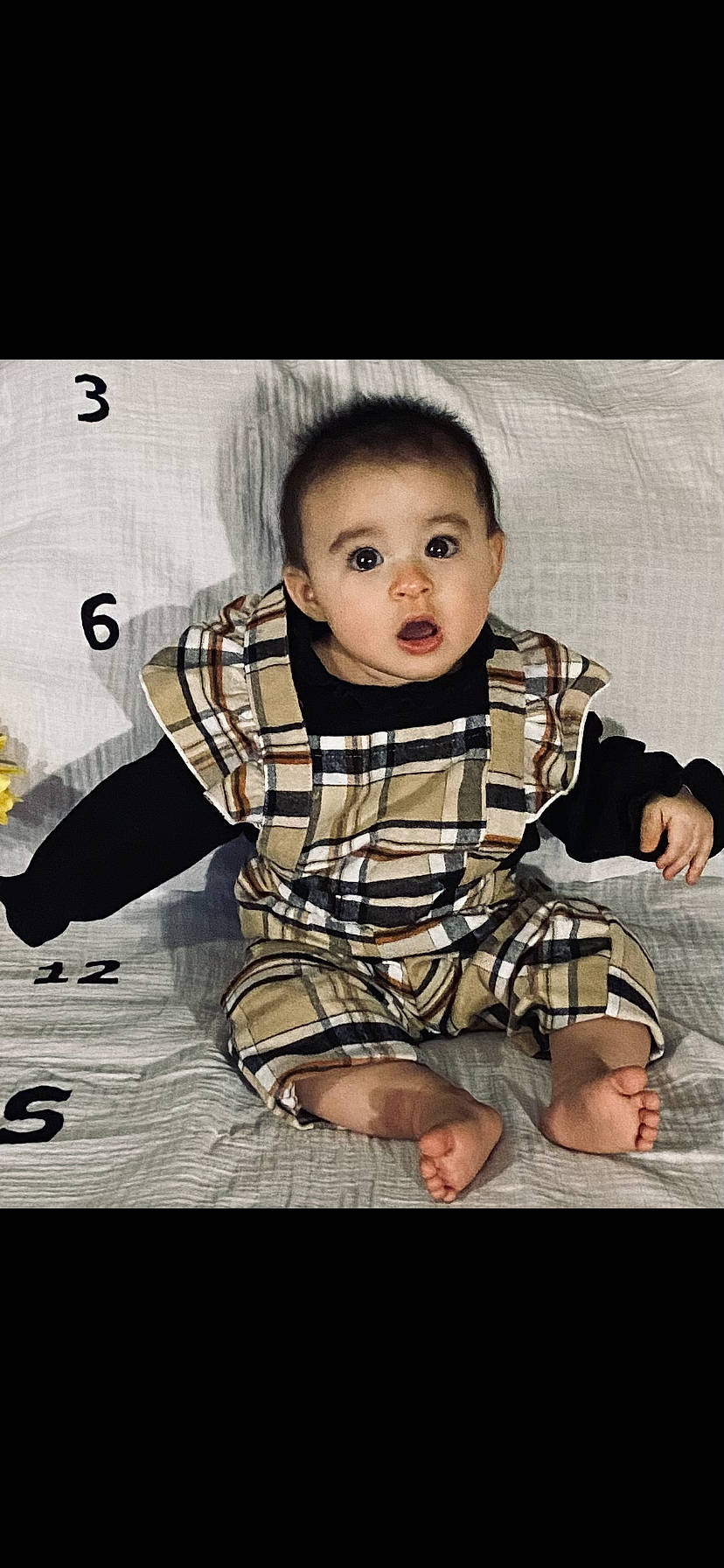 Lydia is registered to the contest to win money with this photo: baby, baby_toddler_clothing, black_hair, cheek, child, collar, dress_shirt, flash_photography, flooring, formal_wear, happy, pattern, person, plaid, portrait_photography, sitting, skin, sleeve, surprise, t_shirt