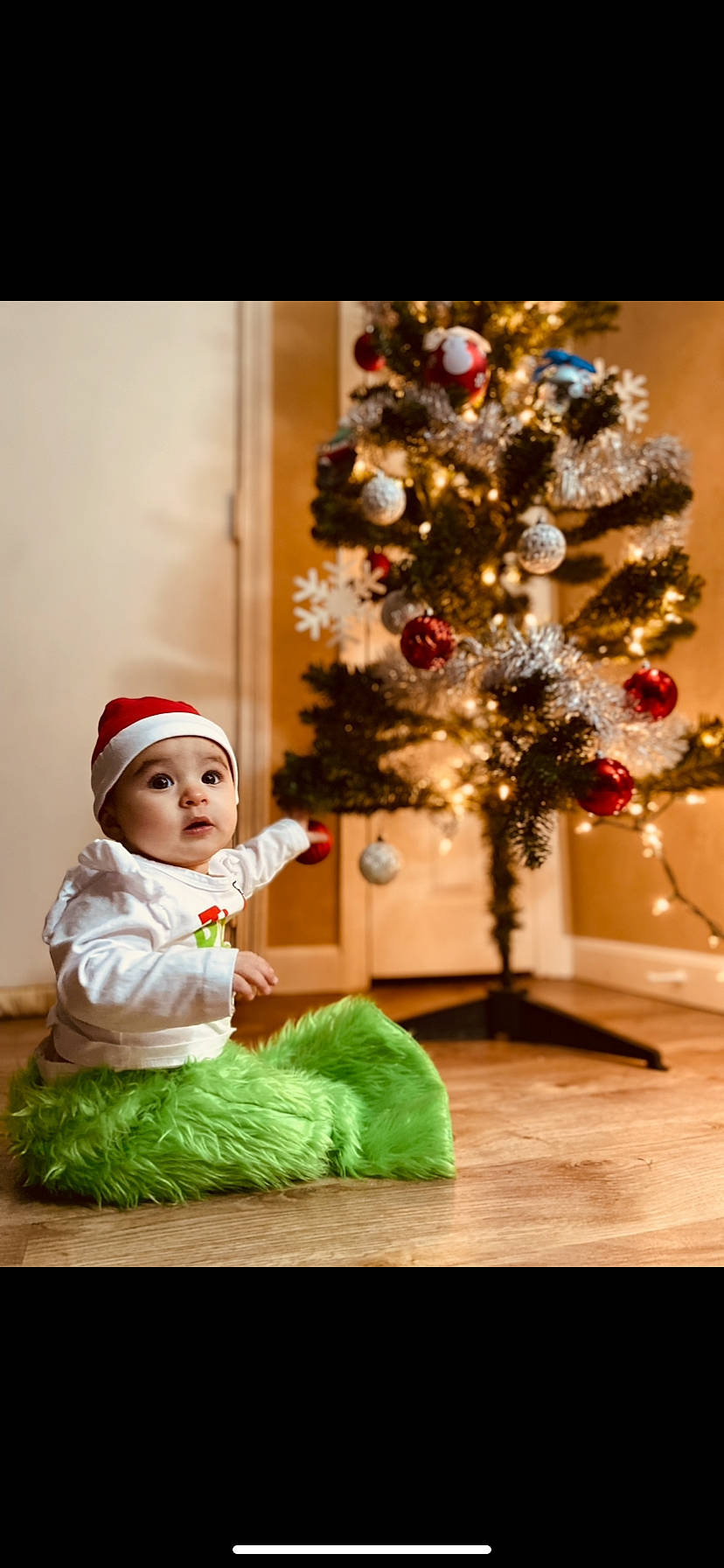 Lydia joined the competition — help win amazing prizes! baby, baby_toddler_clothing, christmas, christmas_decoration, christmas_eve, christmas_ornament, christmas_tree, event, happy, headwear, holiday, holiday_ornament, lighting, ornament, person, plant, room, sitting, snapshot, standing