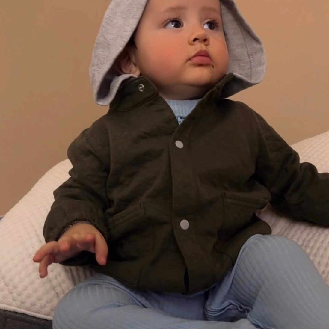 Noah Bautista is registered to the contest to win money with this photo: baby, casual, child, clothing, comfortable, cozy, cute, expression, face, hand, hoodie, indoor, jacket, neutral_background, portrait, sitting, soft_furniture, toddler, warm_lighting, young_child