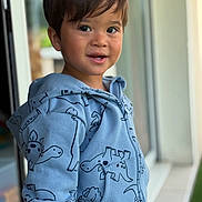 Nicolas a rejoint le concours — aidez-le/la à gagner de superbes lots ! background_blur, casual_clothing, child, cozy, cute, dinosaur_pattern, face, happy, hoodie, indoor, person, playful, plush_toy, portrait, short_hair, smiling, soft_light, toddler, window, young_child