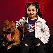Paolo participe au concours pour gagner de l'argent avec cette photo : child, dog, smiling, braided_hair, red_background, black_fur_surface, casual_clothing, happy, pet, indoor, friendship, portrait, sitting, young_girl, animal, leash, studio_photo, cute, tongue_out, companionship