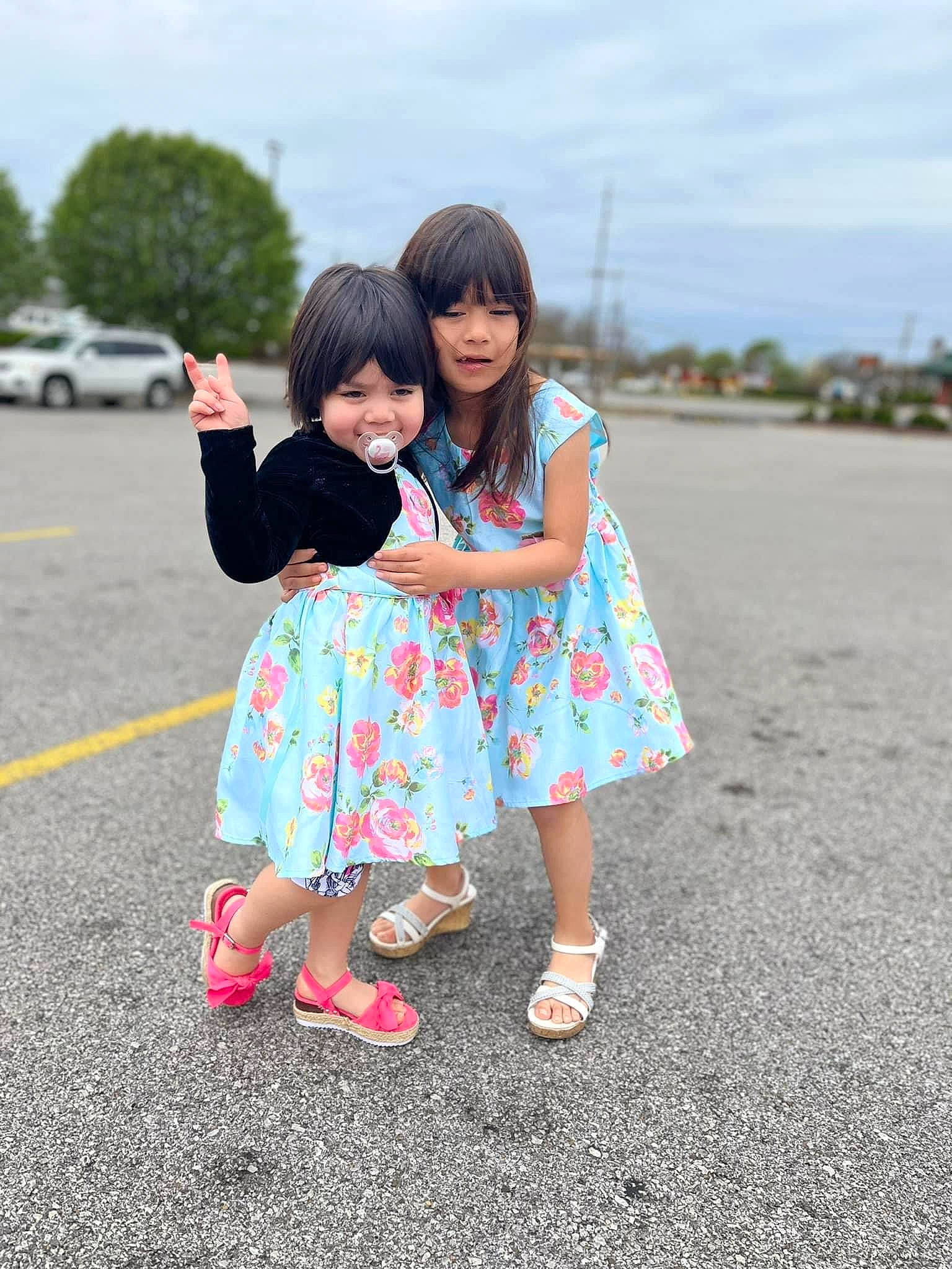 Sisters is registered to the contest to win money with this photo: asphalt, cloud, friendship, gesture, grass, happy, interaction, leisure, person, pink, public_space, recreation, shoe, sky, smile, sneakers, standing, summer, toddler, travel