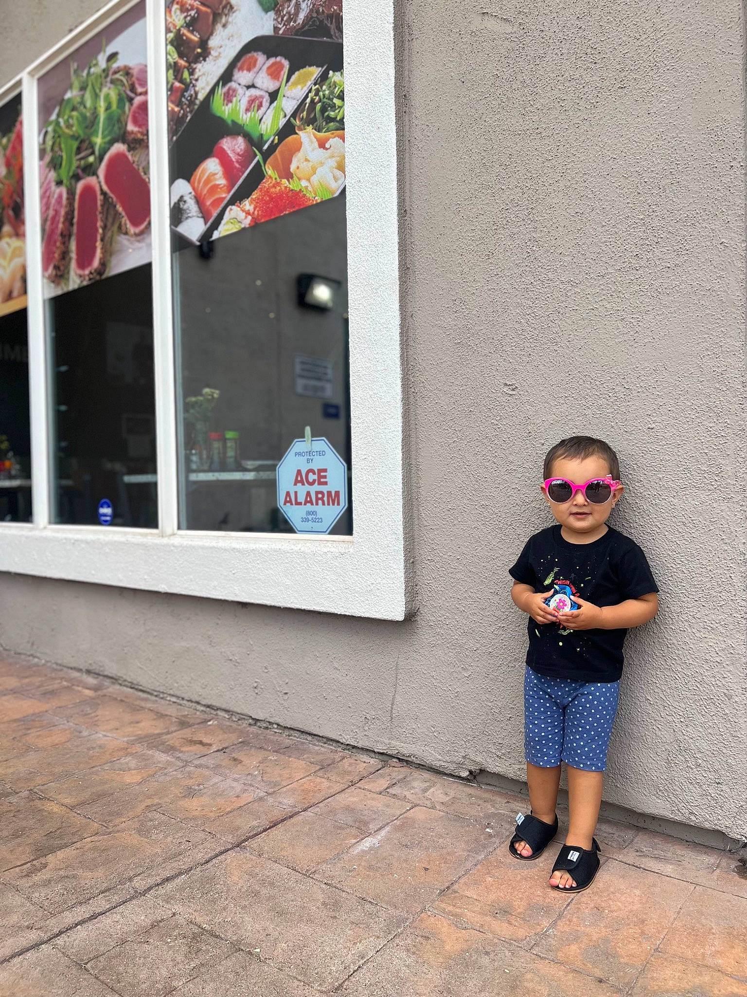 Kailani joined the competition — help win amazing prizes! art, asphalt, building, city, concrete, eyewear, facade, flooring, pattern, pedestrian, person, poster, red, road, road_surface, sidewalk, sunglasses, toddler, vegetable, visual_arts