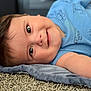airplane, baby, blanket, blue_onesie, bracelet, car, carpet, cheeky, child, closeup, cute, face, hair, happy, indoors, infant, lying_down, skin, smiling, soft