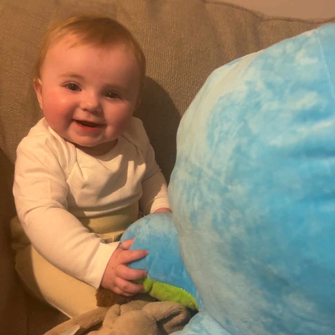 Skyler Ann joined the competition — help win amazing prizes! architecture, baby, bodypart, building, couch, cushion, face, finger, furniture, hand, happy, head, homedecor, indoors, livingroom, person, photography, portrait, room, sitting