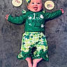baby, infant, child, st_patricks_day, green_clothing, headband, tongue_out, milestone_signs, happy, smiling, lying_down, carpet, celebration, holiday, cute, cheerful, clover_pattern, shorts, long_sleeve, person