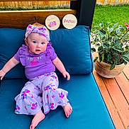 Clair-Ann joined the competition — help win amazing prizes! baby, barefoot, blue_cushion, child, curious_expression, cute, first_easter, floral_pattern, greenery, headband, infant, milestone_signs, outdoor, portrait, potted_plant, purple_clothing, seven_months, sitting, sunlight, wooden_deck