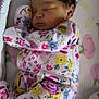 Amylah is registered to the contest to win money with this photo: baby, sleeping, crib, onesie, floral_pattern, newborn, infant, bed, blanket, soft, cute, peaceful, child, pajamas, rest, indoors, person, toddler, comfort, young