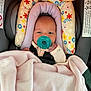 Kenzleigh is registered to the contest to win money with this photo: baby, infant, pacifier, car_seat, blanket, floral_pattern, pink, purple, teal, child, newborn, cute, face, clothing, seat_belt, head_support, indoor, person, comfort, resting