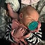 newborn, baby, pacifier, sleeping, infant, pink_clothing, striped_sleeves, hand, face, blanket, soft_light, cozy, cute, portrait, indoors, peaceful, resting, child, young, human
