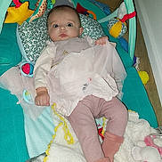 Pauline participe au concours pour gagner de l'argent avec cette photo : baby, infant, play_gym, toy, blanket, soft_toy, pink_clothing, leggings, socks, pillow, floor, indoor, child, cute, curious, baby_girl, plush, comfort, lying_down, home