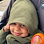 Aureliano is registered to the contest to win money with this photo: toddler, child, hoodie, green_clothing, smile, toy, colorful, stroller, seatbelt, face, person, outdoor, closeup, baby, hand, expression, cute, warm_clothing, happy, play