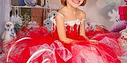 Erin a rejoint le concours — aidez-le/la à gagner de superbes lots ! child, tutu_dress, red_dress, barefoot, holiday, christmas, candy_cane, gingerbread, gift_box, decorations, blocks, smiling, portrait, festive, floor, carpet, indoors, happy, girl, background_blur