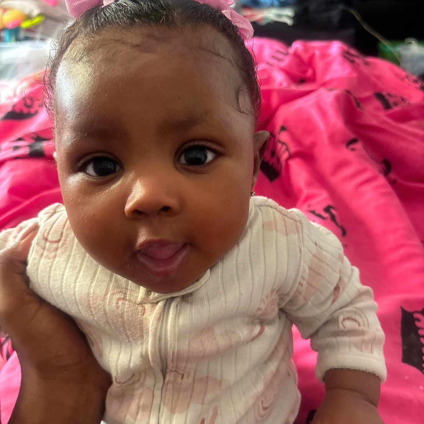 Semajah joined the competition — help win amazing prizes! baby, child, infant, face, pink_bows, hand, clothing, blanket, indoor, portrait, cute, expression, person, young_child, sitting, closeup, skin, eyes, mouth, holding