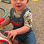 Brooks is registered to the contest to win money with this photo: toddler, child, toy, carpet, indoor, play, overalls, shirt, plush_toy, dragon, smile, face, hand, knee, colorful, room, door, floor, cute, curious