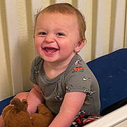 Brooks joined the competition — help win amazing prizes! toddler, child, smiling, happy, stuffed_animal, toy, crib, bed, baby_clothes, short_sleeve_shirt, indoor, person, face, head, hair, skin, furniture, playtime, cute, joyful