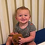 Brooks joined the competition — help win amazing prizes! toddler, child, smiling, sitting, crib, stuffed_animal, toy, clothing, indoor, baby, happy, face, person, furniture, bed, cute, young_child, playful, comfort, home