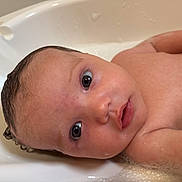 Ivy is registered to the contest to win money with this photo: baby, bathtub, water, soap_bubbles, skin, face, eyes, infant, wet_hair, bath_time, child, cute, portrait, close_up, curious, young, human, indoors, bath, clean