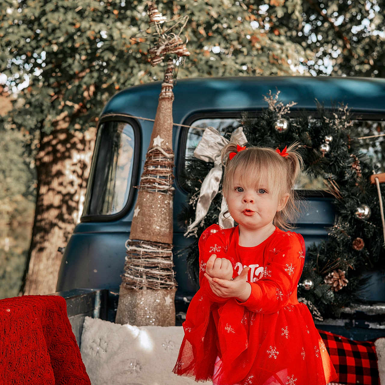 Ali Mae is registered to the contest to win money with this photo: blanket, child, christmas, cute, decorations, festive, girl, holiday, ornaments, outdoor, pillow, playful, portrait, red_dress, smiling, toy, tree, vintage_truck, winter, wreath