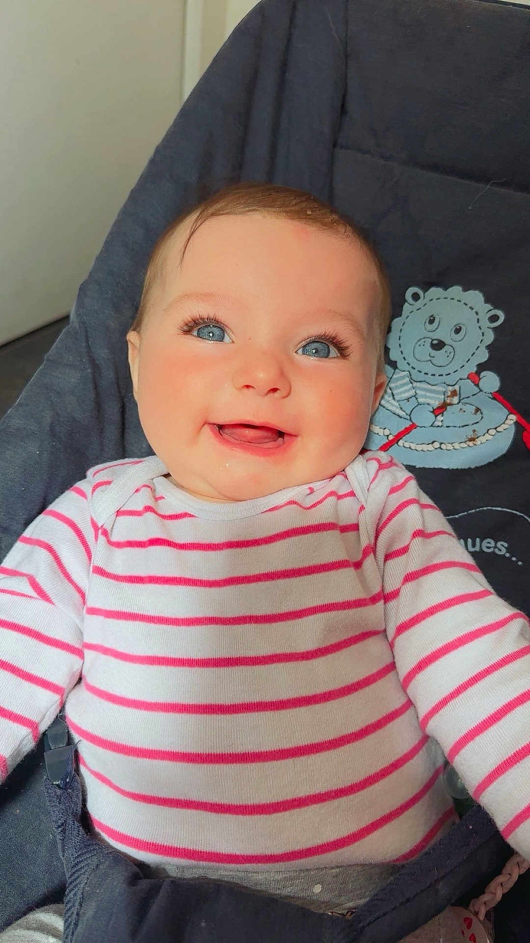 Maëlyss a rejoint le concours — aidez-le/la à gagner de superbes lots ! baby, smiling, blue_eyes, striped_clothing, onesie, infant, happy, cute, face, portrait, child, seated, indoors, cushion, plush_toy, clothing, person, closeup, cheerful, young_child