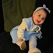 Taliyah joined the competition — help win amazing prizes! baby, child, smiling, headband, earrings, blue_dress, white_tights, shoes, couch, pillow, indoor, portrait, happy, cute, young_child, sitting, fashion, soft_lighting, face, person