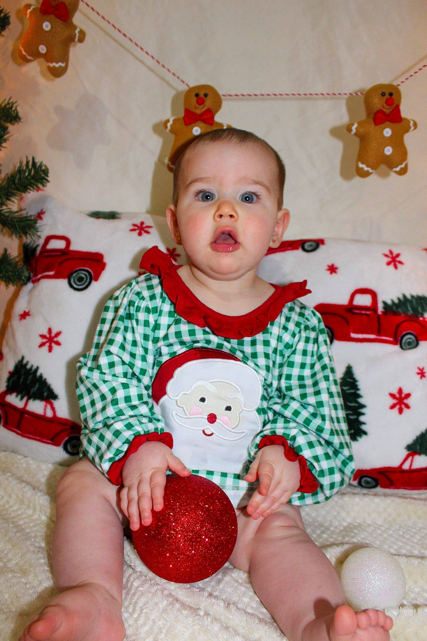 Alora is registered to the contest to win money with this photo: baby, baby_toddler_clothing, child, christmas, christmas_decoration, christmas_ornament, event, facial_expression, happy, holiday, human_body, pattern, person, red, skin, sleeve, sock, surprise, textile, thigh