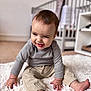 Oakley joined the competition — help win amazing prizes! baby, child, smiling, happy, indoor, striped_shirt, beige_pants, sitting, rug, fluffy, cute, infant, person, face, hands, feet, crib, furniture, home, portrait