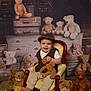 baby, child, teddy_bear, chair, smile, vintage_clothing, hat, stuffed_animal, attic, suitcase, wooden_furniture, plush_toy, portrait, indoor, cute, happy, floor_rug, seated, person, cozy