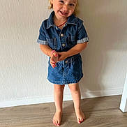 Nelya participe au concours pour gagner de l'argent avec cette photo : child, girl, denim, dress, barefoot, floor, smile, hair_bow, standing, wooden_floor, happy, indoors, portrait, cute, casual_clothing, young, person, fashion, playful, skin