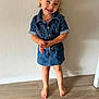 child, girl, denim, dress, barefoot, floor, smile, hair_bow, standing, wooden_floor, happy, indoors, portrait, cute, casual_clothing, young, person, fashion, playful, skin