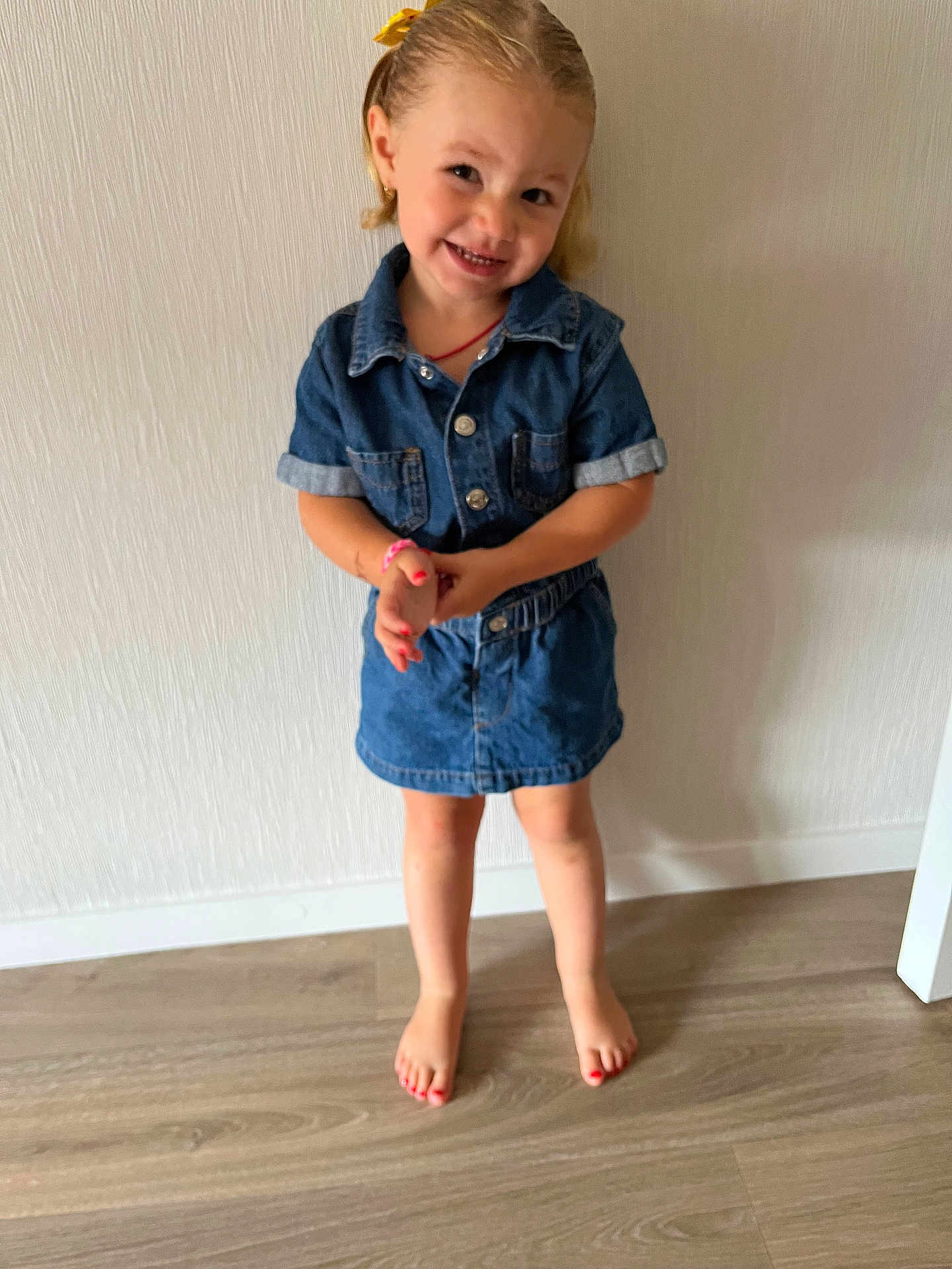 Nelya participe au concours pour gagner de l'argent avec cette photo : child, girl, denim, dress, barefoot, floor, smile, hair_bow, standing, wooden_floor, happy, indoors, portrait, cute, casual_clothing, young, person, fashion, playful, skin