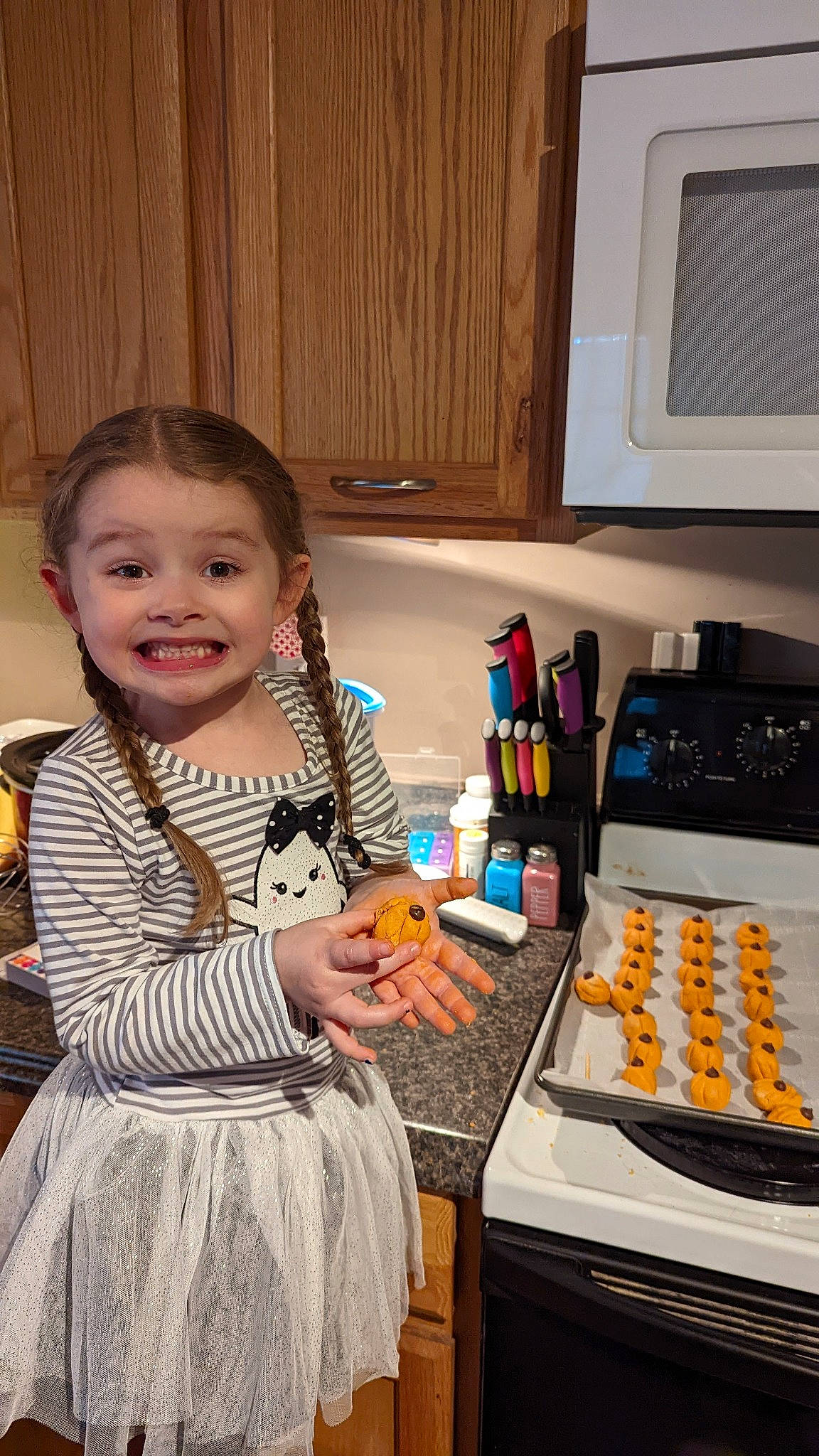 Emma is registered to the contest to win money with this photo: baking, cabinetry, cake, computer_keyboard, cooking, dress, food, home_appliance, joy, kitchen, kitchen_appliance, machine, microwave_oven, office_equipment, person, plate, recipe, room, smile, table