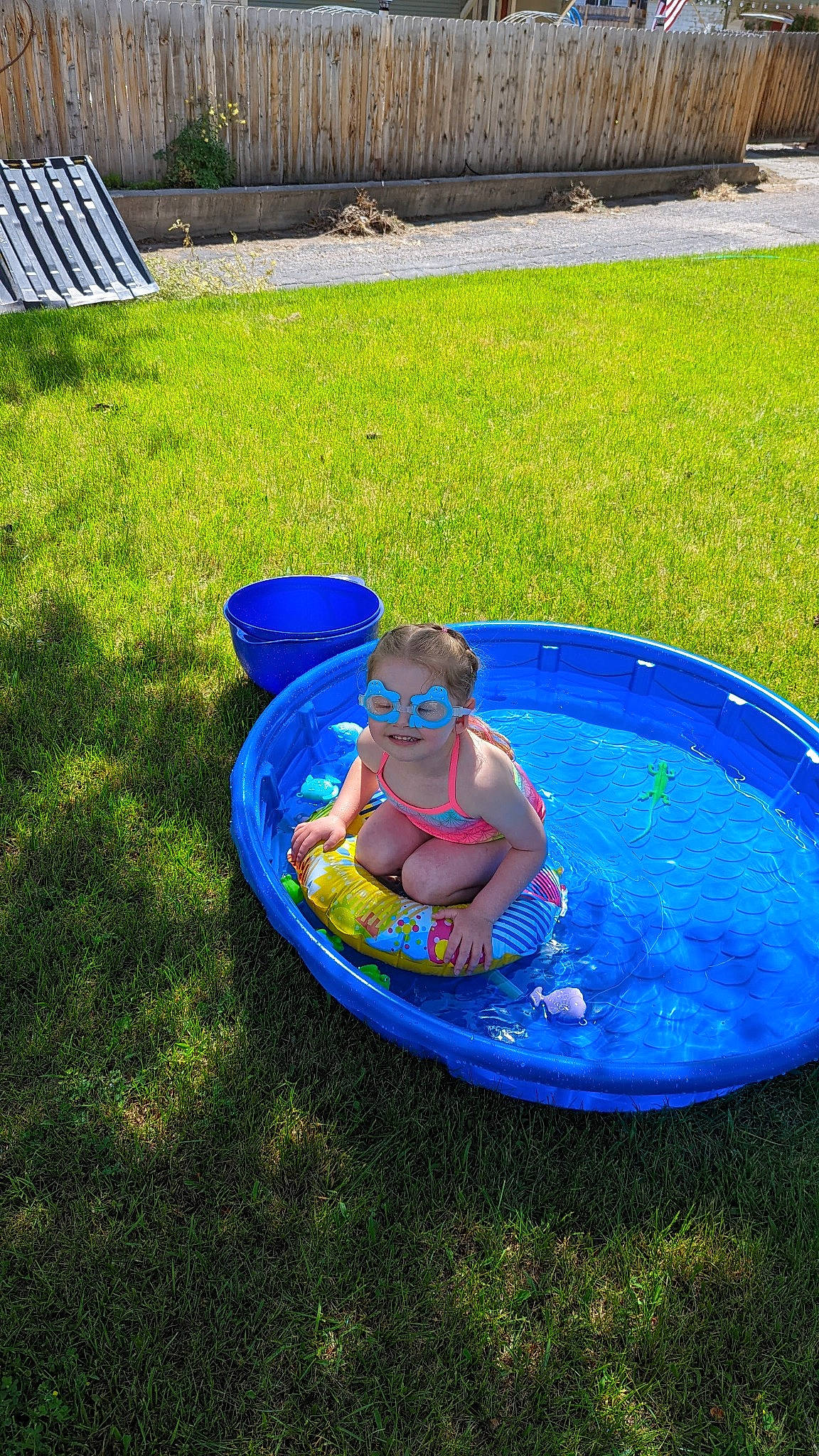 Emma is registered to the contest to win money with this photo: baby, bathing, blue, child, electric_blue, fun, games, garden, grass, inflatable, joy, lawn, leisure, nonbuilding_structure, outdoor_furniture, person, play, recreation, toddler, vacation
