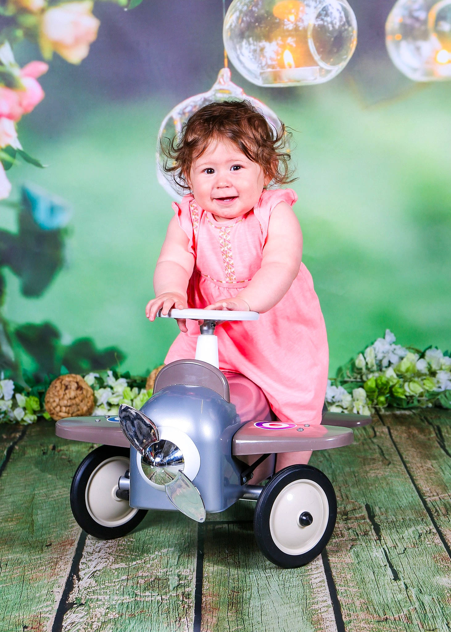 Talia a rejoint le concours — aidez-le/la à gagner de superbes lots ! beauty, child, dress, flower, grass, green, happy, people, people_in_nature, person, petal, pink, plant, riding_toy, smile, summer, tire, toddler, toy, vehicle