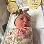 baby, baby_bed, baby_boy, baby_clothing, baby_face, baby_girl, baby_wrap, blanket, cute, floral_pattern, headband, hospital, infant, newborn, newborn_care, peaceful, portrait, puckered_lips, soft_lighting, swaddle