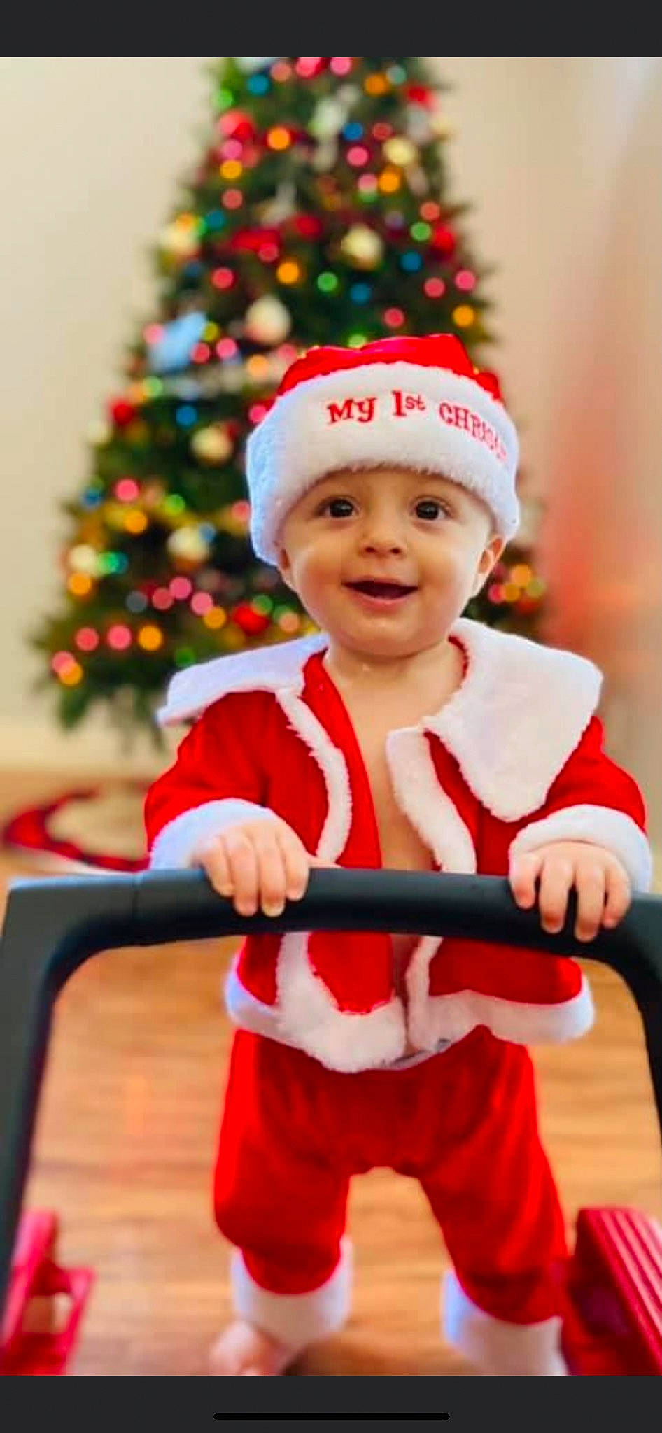 Memphis Todd Stone is registered to the contest to win money with this photo: baby, christmas, christmas_decoration, christmas_ornament, christmas_tree, event, face, green, happy, headwear, holiday, holiday_ornament, joy, ornament, person, red, santa_claus, sleeve, smile, standing
